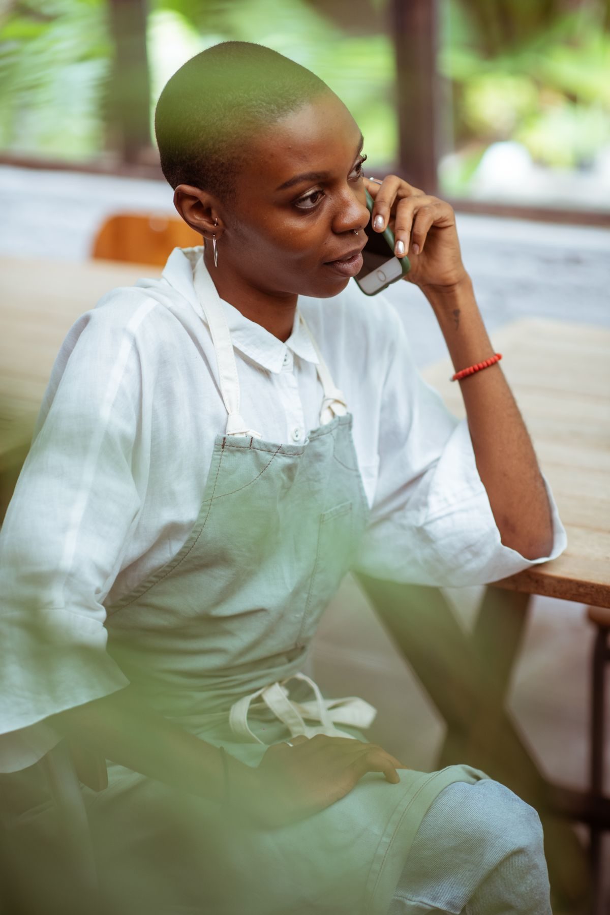 Owner in an apron connecting her accounts on her phone