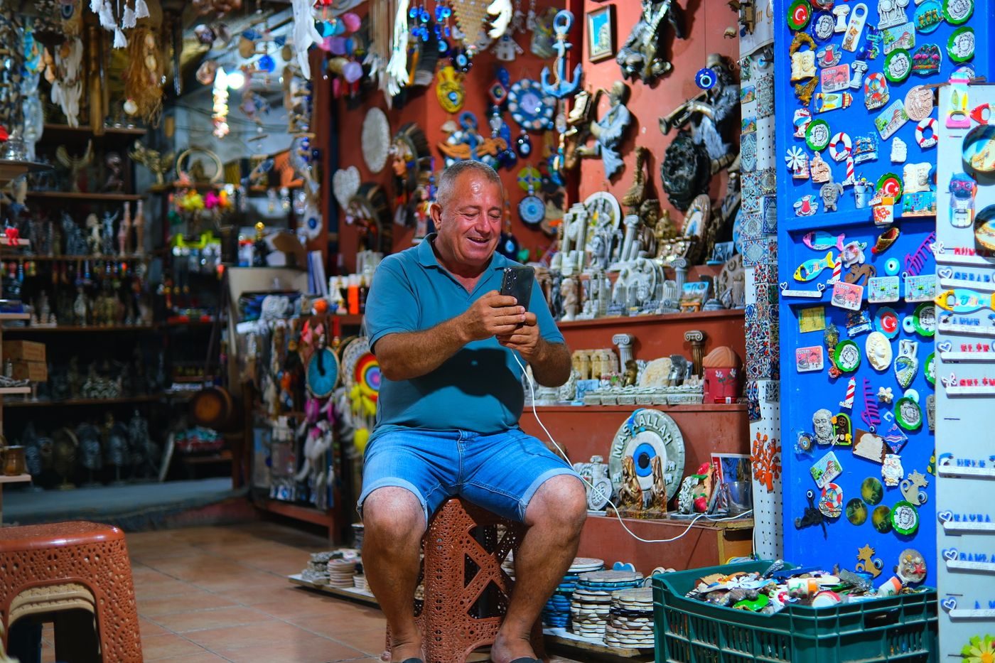 Shop owner checking his phone among his stock